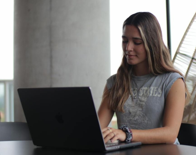 a woman sitting at a table with a laptop